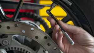 Checking motorcycle tire pressure with an analogue pressure checker